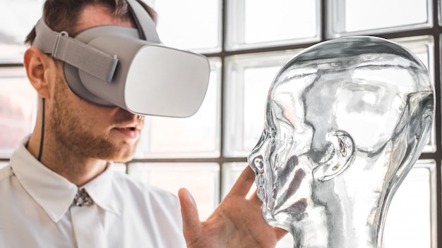 Un giovane medico che indossa occhiali di protezione VR che esamina un manichino in simulazione VR