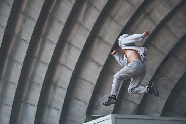 Un giovane sta saltando. Parkour nello spazio urbano, attività sportiva.