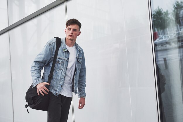 Un giovane uomo bello all'aeroporto sta aspettando il volo.