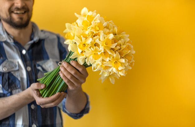 Un giovane uomo sorridente con un mazzo di fiori primaverili