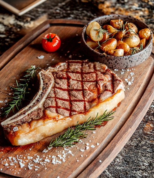 Un grosso pezzo di carne fritta grassa per bistecca con patate