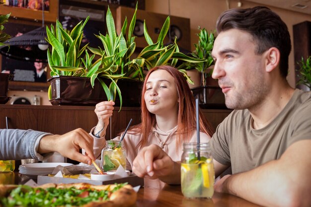 Un gruppo di amici che riposa in un pub. Mangiare, bere, cibo in tavola. Amicizia