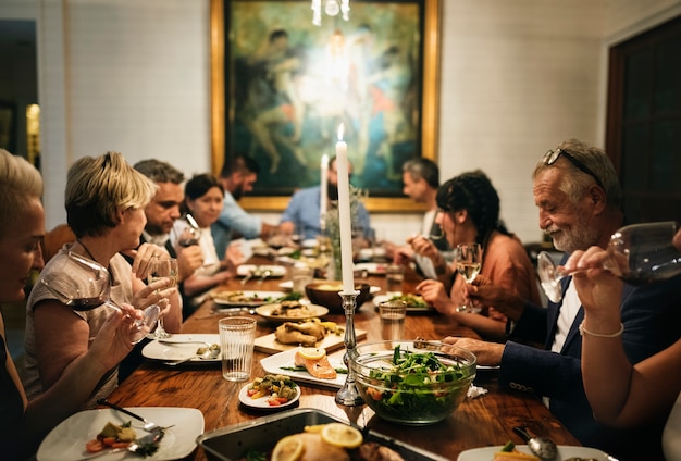 Un gruppo di amici diversi stanno cenando insieme