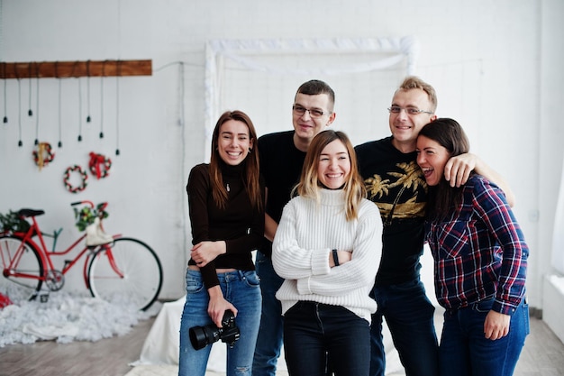 Un gruppo di cinque persone amici fotografi e designer in studio di riprese dopo una dura giornata di lavoro Sono felici e ridono