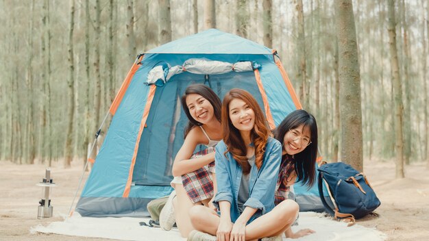 Un gruppo di giovani amici campeggiatori asiatici che si accampano vicino si rilassano e si godono il momento nella foresta