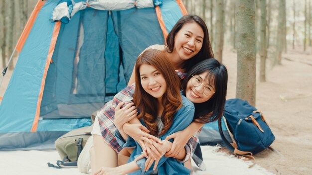 Un gruppo di giovani amici campeggiatori asiatici che si accampano vicino si rilassano e si godono il momento nella foresta
