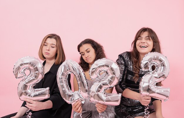 Un gruppo di ragazze con palloncini in lamina d'argento a forma di numeri
