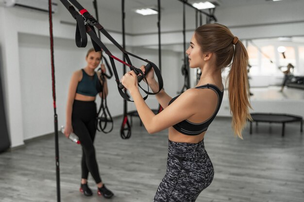 Un gruppo di sportivi si sta allenando all'aperto con TRX