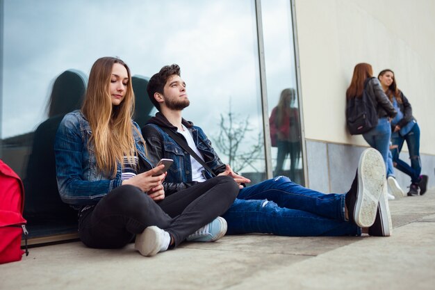 Un gruppo di studenti che si divertono con gli smartphone dopo la classe.