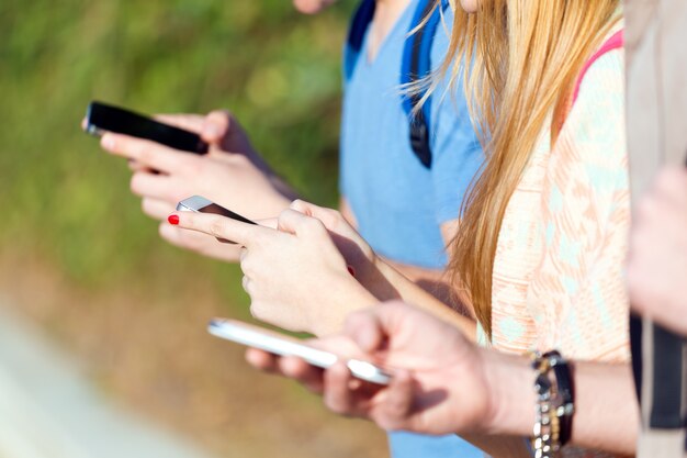 Un gruppo di studenti che si divertono con gli smartphone dopo la classe.