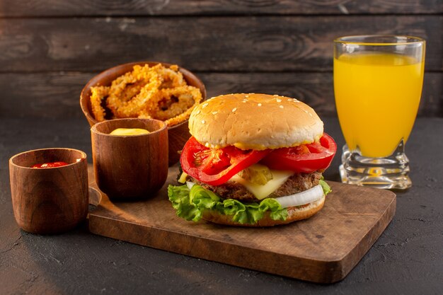 Un hamburger di pollo vista frontale con formaggio e insalata verde sulla scrivania in legno e cibo pasto fast food sandwich