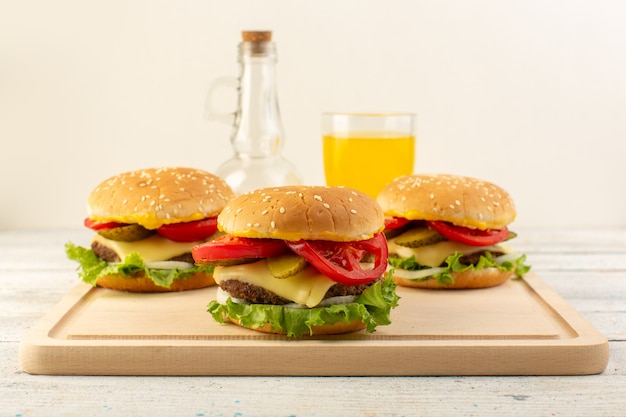 Un hamburger di pollo vista frontale con succo di insalata verde di formaggio e olio d'oliva sullo scrittorio di legno e cibo pasto fast-food sandwich