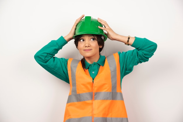 Un ingegnere femminile in possesso di un casco su sfondo bianco. Foto di alta qualità