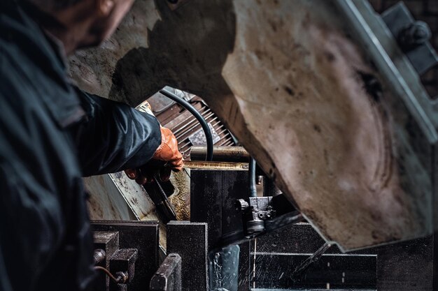 Un lavoratore esperto lavora in una fabbrica di metalli utilizzando macchine utensili speciali.