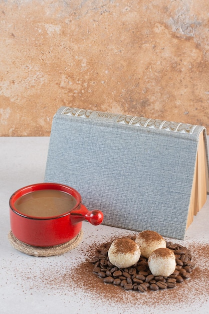 Un libro con aroma gustosa tazza di caffè su sfondo bianco. Foto di alta qualità