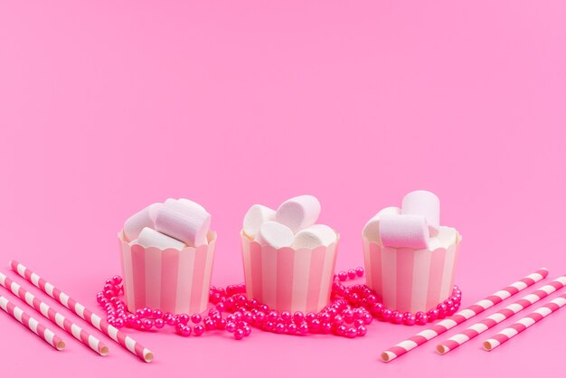 Un marshmallow bianco vista frontale all'interno di pacchetti di carta rosa isolati su rosa