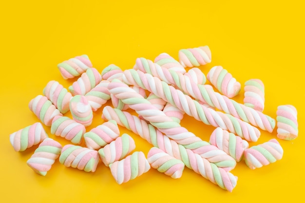 Un marshmallow dolce vista frontale isolato sullo scrittorio giallo, colore dolce dello zucchero candito