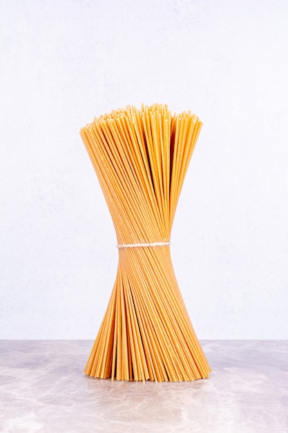 Un mazzo di spaghetti isolato sullo spazio di marmo.