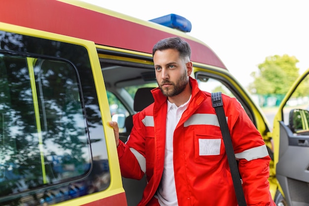 Un membro del personale dell'ambulanza emerge dal retro di un'ambulanza con il suo zaino di emergenza e il monitor dei parametri vitali