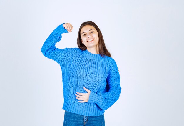 un modello di ragazza sorridente che mostra i suoi bicipiti.