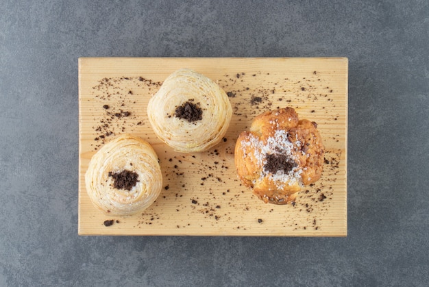 Un muffin alle noci con pasticcini e cacao in polvere su una tavola di legno