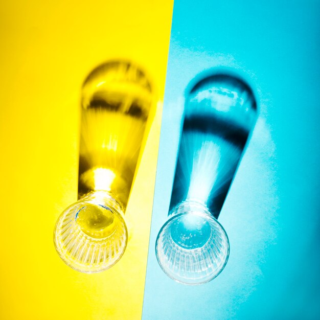 Un&#39;ombra di vista sopraelevata di occhiali su doppio sfondo giallo e blu