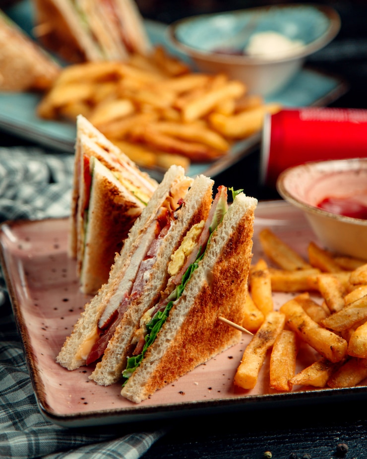 Foto gratuito un panino da club con prosciutto e omelette e patate.