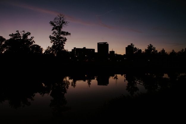 Un parco in città con il riflesso del lago dell'edificio all'alba