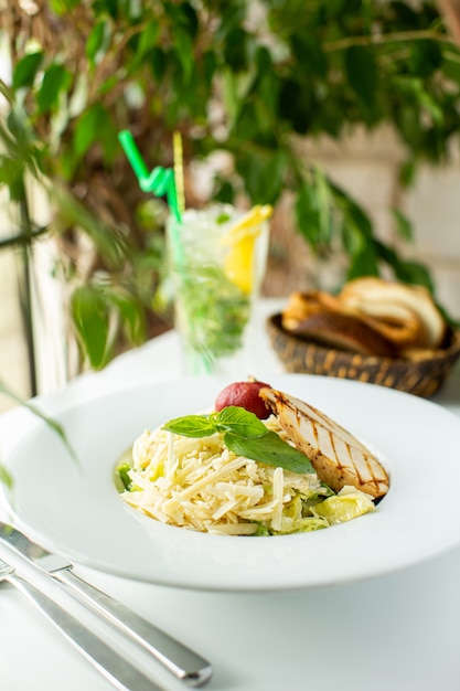 Un pasto gustoso vista da vicino vista frontale cucinato pasta con foglia verde e carne all'interno del piatto bianco sulla scrivania bianca