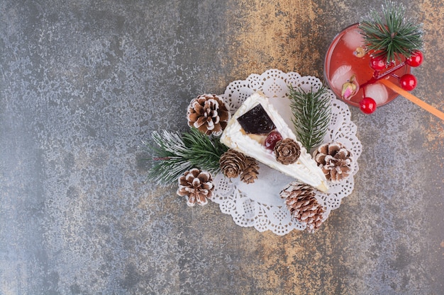 Un pezzo di torta con pigne e succo di fragola freddo con paglia