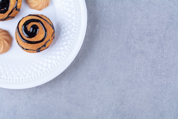 Un piatto bianco di deliziosi biscotti dolci con sciroppo di cioccolato.