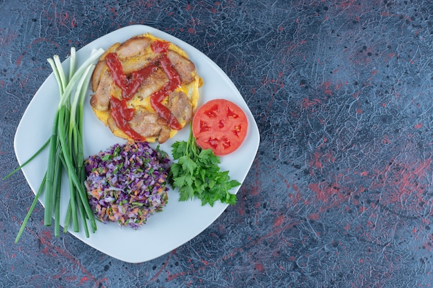 Un piatto bianco di frittata con erbe e cipolle verdi.