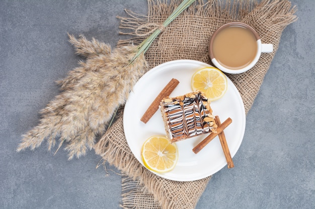 Un piatto bianco di torta cremosa con una tazza di caffè delizioso.