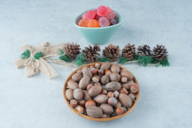 Un piatto blu di marmellata con piccole pigne di Natale su sfondo di marmo. Foto di alta qualità