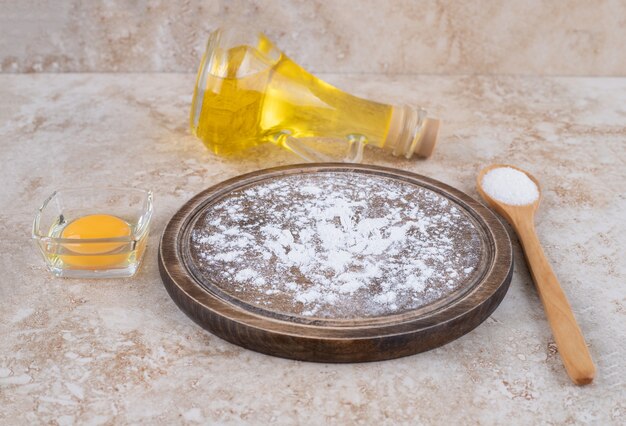 Un piatto di farina marrone e una tazza di latte di vetro