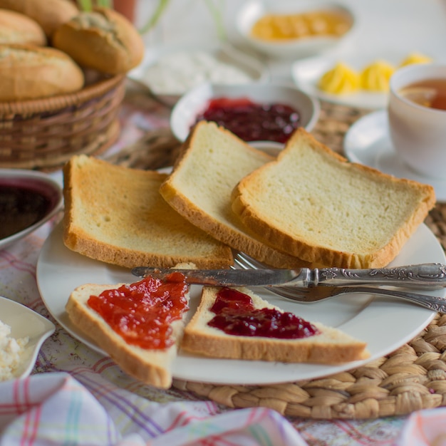 Un piatto di fette di pane tostato quadrato e toast triangolari con marmellata