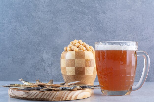 Un piatto di legno pieno di delizioso pesce con birra e piselli