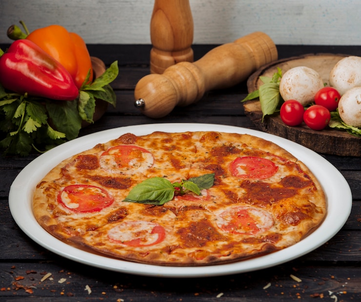 Foto gratuito un piatto di pizza margherita guarnita di basilico