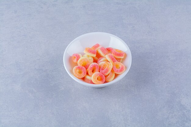 Un piatto fondo pieno di marmellate zuccherate di frutta colorata