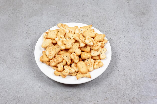 Un piatto pieno di cracker croccanti su fondo di marmo. Foto di alta qualità