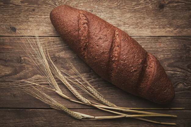 Un po 'di pane e grano su legno, piatto laici.