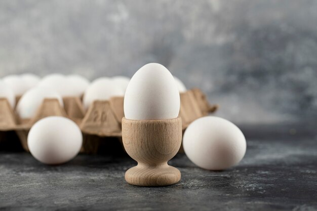 Un portauovo in legno con uovo di gallina bollito.