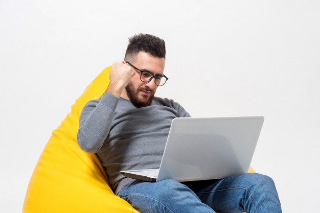 Un ragazzo si rallegra mentre lavora al computer portatile