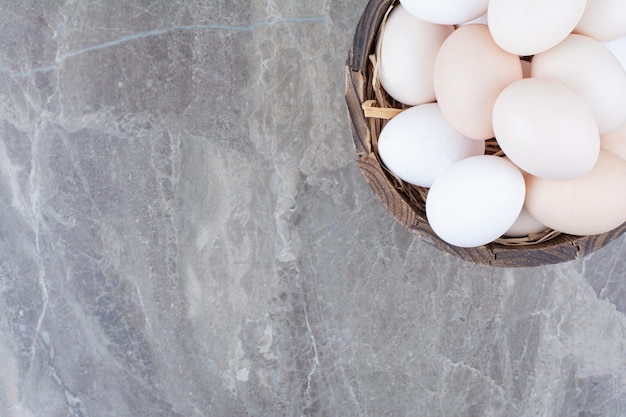 Un sacco di uova bianche di pollo fresco sulla ciotola di legno. Foto di alta qualità