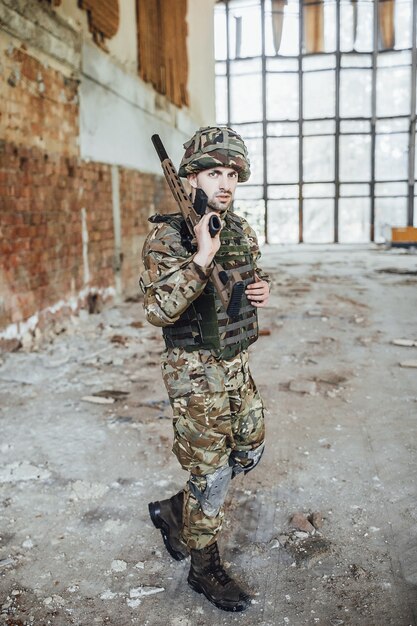 Un soldato in uniforme indossa un grosso fucile tra le mani