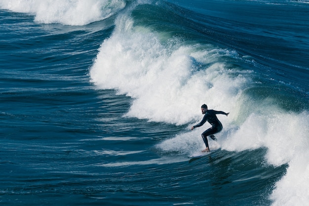 Un surfista che naviga nel mare con belle onde