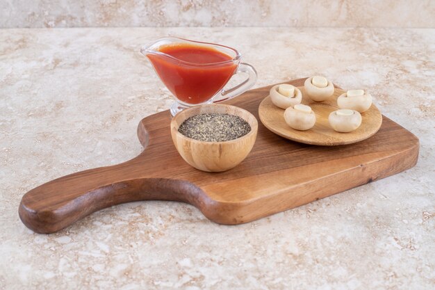 Un tagliere di legno con funghi e ketchup