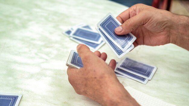 Un uomo che gioca a carte con altre persone che mescolano un mazzo