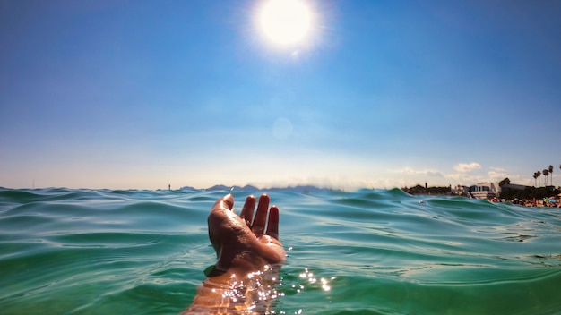 Un uomo che tiene la mano sopra l'acqua, mare Mediterraneo