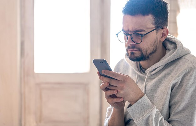 Un uomo con gli occhiali utilizza uno spazio di copia per smartphone